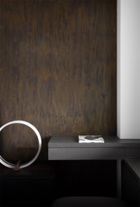 A minimalist desk space featuring a black wooden floating desk with a metallic circular light fixture and a book.