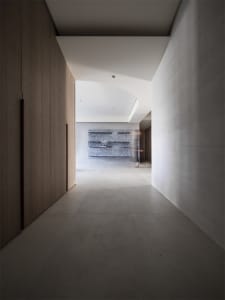 Minimalist modern corridor featuring exposed concrete walls and floor, creating a sleek and contemporary atmosphere.