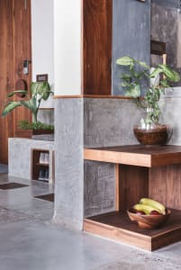 A modern entryway featuring concrete and walnut wood materials.