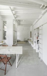 Modern minimalist office space with concrete walls and white furniture