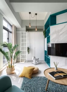 A modern minimalist living room with concrete walls, a turquoise accent wall, and a combination of white, turquoise, and teal