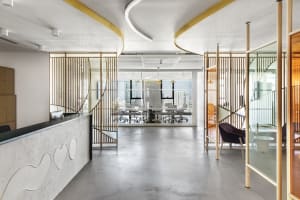 A modern office space featuring concrete and glass walls with large windows.