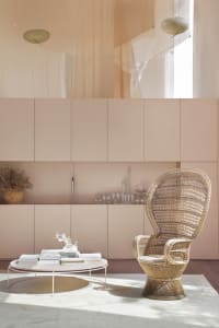 A cozy and stylish interior space with a modern wicker chair, coffee table, and cabinets.