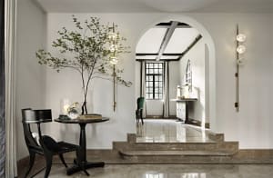 A minimalist living room featuring marble floors and a modern arched doorway.