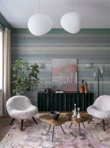 Modern living room with metallic tables, green-wood cabinet, and suede armchairs.