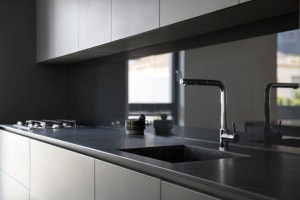 Modern kitchen interior with granite countertop and stainless steel faucet.