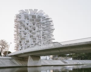 A modern residential building with a unique concrete exterior and multiple balconies.