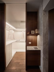 Modern closet with white marble countertops, wooden shelves, and a minimalist design.
