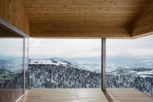 Modern window with glass walls overlooking snowy mountains