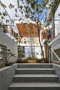 A modern industrial-style house featuring a concrete exterior and a central courtyard with greenery.