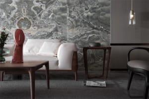 A modern living room with a marble wall, white sofa, and wooden coffee table.
