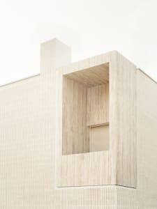 Sandstone exterior wall of a modern, minimalist building.