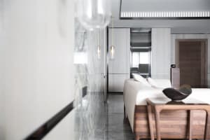 A contemporary living room featuring marble and wood elements.