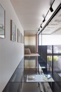 A modern minimalist living space featuring glass elements.