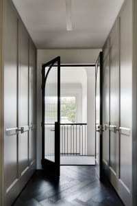 A modern interior with a black-framed glass door panel, showcasing clean lines and minimalist design features.