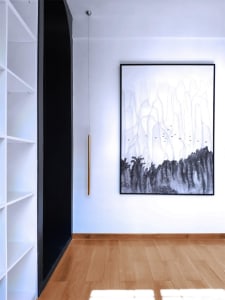 A modern interior featuring a large abstract painting of silver and gray colors with vertical lines.