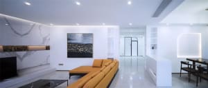 Modern minimalist living room with white marble floor, orange sectional sofa, and black coffee table.