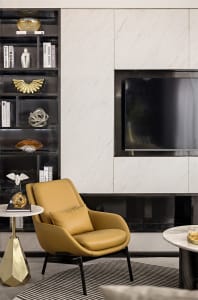 A modern living room featuring a marble wall and a yellow leather armchair.