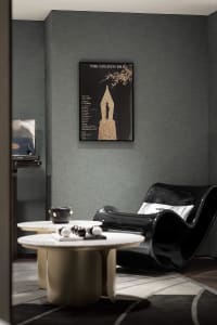 A modern living room featuring metal, leather, and fabric furnishings and a black curved chair.