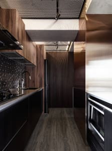 A modern minimalist kitchen with wood accents and dark wooden cabinets.