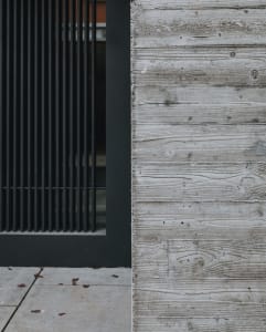Modern minimalist building exterior featuring textured concrete panels