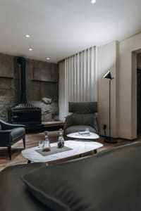 Modern minimalist living room featuring marble coffee tables and a leather armchair, providing a comfortable and sophisticate