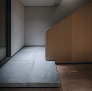 A minimalist space with concrete flooring and wooden walls.