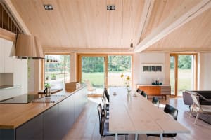 A contemporary residential kitchen featuring wood elements and large windows.