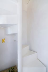 White minimalist staircase with white walls and railings.