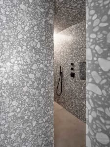Modern bathroom with white and gray terrazzo wall tiles.