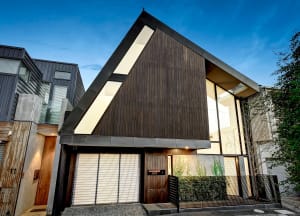 Modern house with dark wood facade and large windows.