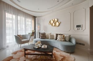 Modern living room featuring fabric furniture, glass accents, and metallic elements.