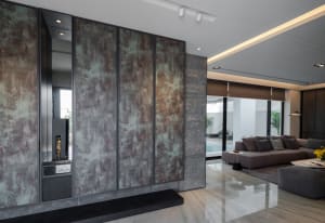 A modern living room featuring metallic panel walls and a sleek seating area.
