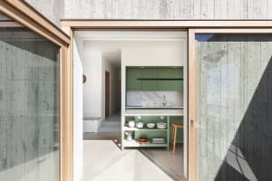 Modern green kitchen featuring minimalist design and concrete construction.