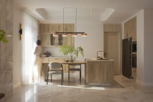 Modern minimalist kitchen interior with wood cabinets and marble floor.