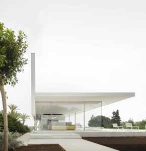 A contemporary residential exterior with large glass panels and a minimalist design.