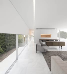 Modern residential kitchen with white marble countertops, white marble flooring, and minimalist design.