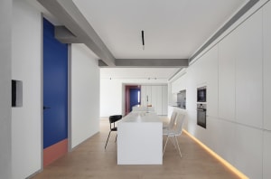 A modern, minimalist kitchen with white cabinets and accents.
