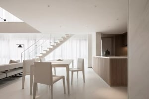 Modern minimalist residential interior with white furniture, wooden accents, and a light-filled space.