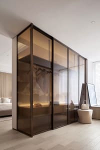 A modern closet with glass doors, showcasing elegant design and minimalist aesthetics.