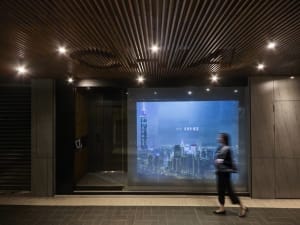 Digital display showing a cityscape at night with Taipei 101 tower illuminated.