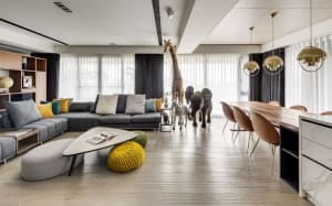 A modern living room with a sectional sofa, coffee table, and floor-to-ceiling windows, featuring a mix of wood and fabric el