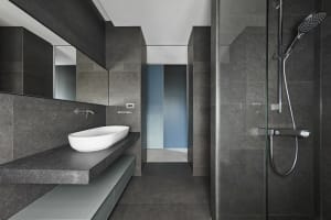 A modern bathroom with a concrete sink and floor.