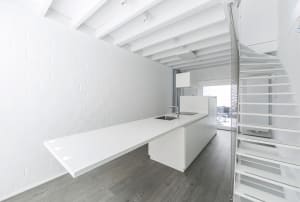 Modern, minimalist kitchen with white cabinets and sleek design.