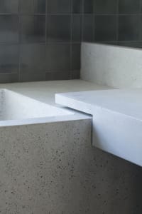 A minimalist bathroom featuring concrete walls and flooring.