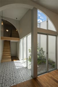 A minimalist living room featuring wooden floors and glass walls and doors.