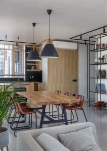 Modern dining room with wooden furniture, black pendant lights, and a mix of leather and metal chairs.
