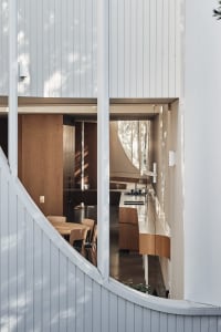 A modern kitchen with white paneling and wooden features.