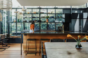 A modern minimalist kitchen featuring glass and wood elements.
