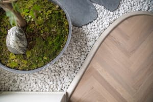 A modern floor design featuring concrete flooring and white pebbles.